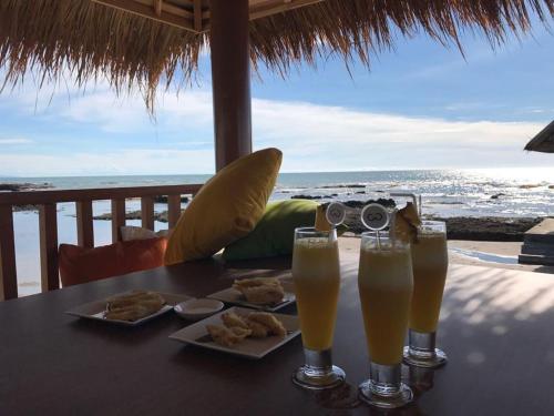 a table with two glasses of beer and some food at Double G Resort Anyer in Carita