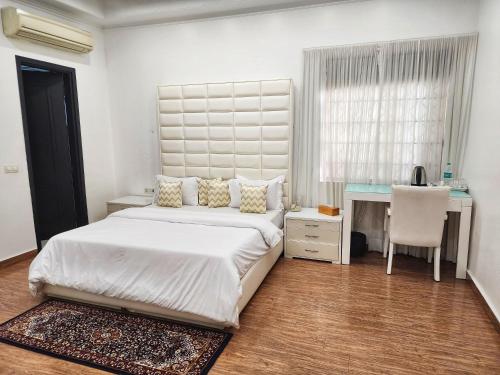 a bedroom with a bed and a desk and a chair at The G8 in Noida