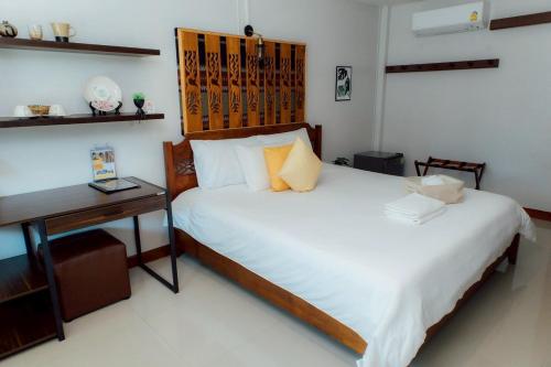 a bed in a room with a desk and a bed at Gita's House in Chiang Rai