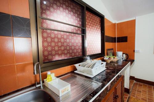 a kitchen counter with a sink and a window at Gita's House in Chiang Rai