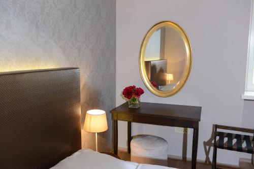 a bedroom with a table and a mirror at B&B Castanea in Kostanjevica na Krki