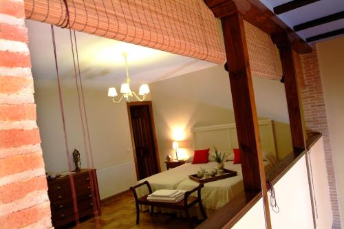 a bedroom with a bed and a table and chairs at Casa Rural Alcancia in Consuegra
