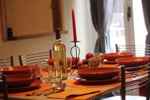 - une table avec des assiettes rouges et une bouteille de vin dans l'établissement Casa P&G, à Niscemi