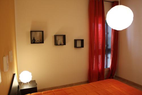 a bedroom with two lights on the wall and two pictures at Casa P&G in Niscemi