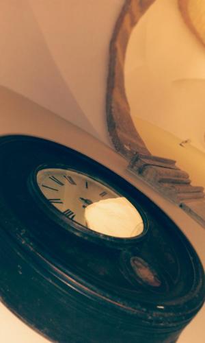 a clock sitting in front of a mirror at Casa P&G in Niscemi
