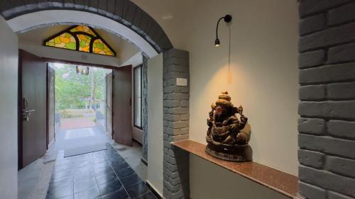 a hallway with a brick wall and a stained glass window at Riveredgemanor in Pālghar