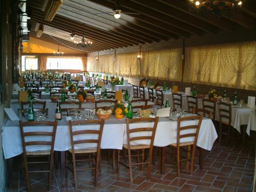 un gran salón de banquetes con mesas y sillas y comida en Agriturismo La Crocetta, en San Giovanni in Persiceto