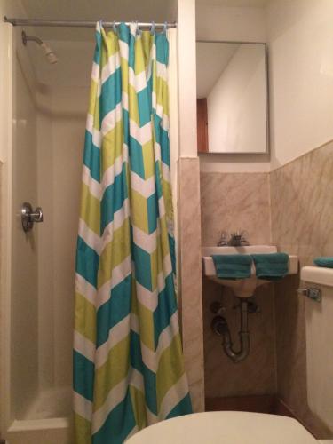 a bathroom with a shower curtain next to a sink at Surfside Inn Chatham in Chatham