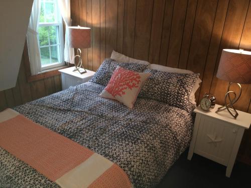 a bedroom with a bed with pillows and two lamps at Surfside Inn Chatham in Chatham