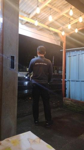 a man standing in a garage holding a hose at Open trip murah kawah ijen in Giri