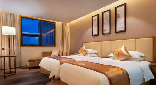 a hotel room with two beds and two windows at Fliport Garden Hotel Nanjing in Nanjing