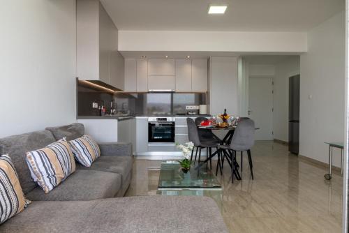 a living room and kitchen with a couch and a table at AURA Apt Modern 1BR in Central Limassol and Free Parking in Limassol