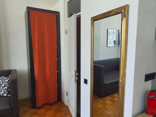 an orange door and a mirror in a room at WHLIVING - Apartments & Studios in Konstanz in Konstanz