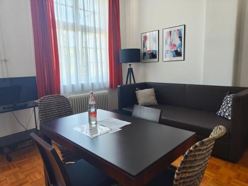 a living room with a table and a couch at WHLIVING - Apartments & Studios in Konstanz in Konstanz