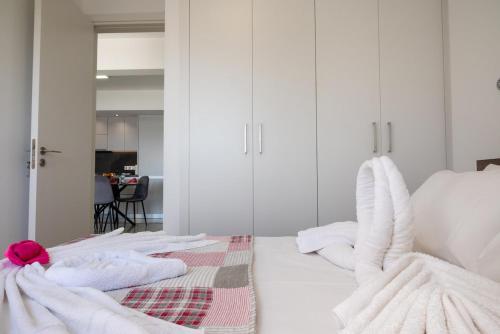 a room with two beds with white walls and a mirror at AURA Apt Modern 1BR in Central Limassol and Free Parking in Limassol