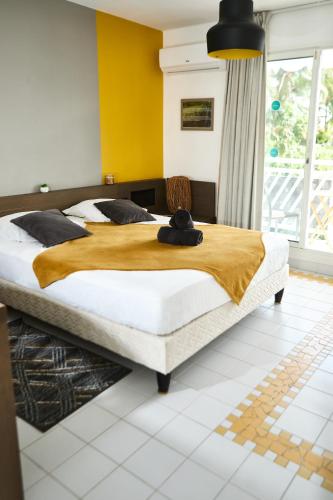 a bedroom with two beds and a yellow wall at Studio Sucre de Canne - Résidence calme avec plage et piscine privées in Saint-François