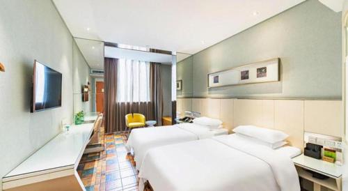 a hotel room with two beds and a desk at Zaozhuang Hotel in Zaozhuang