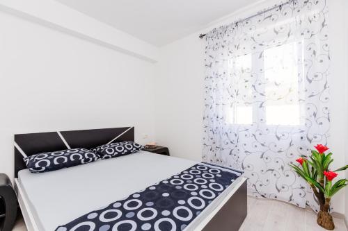 a bedroom with a bed and a window at Dream Vacation Apartments in Tivat