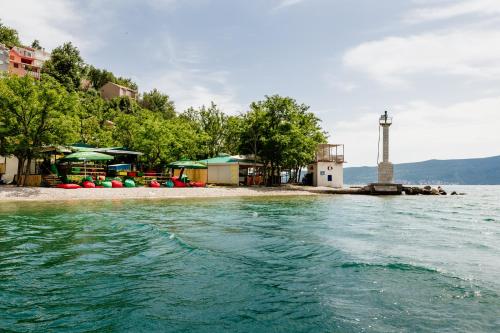 a small island with a lighthouse in the water at Dream Vacation Apartments in Tivat