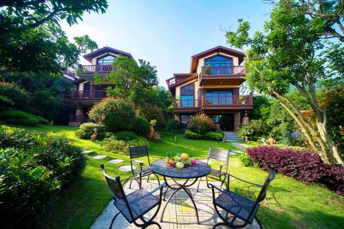 a table and chairs in front of a house at Avatar Valley Villas in Zhangjiajie