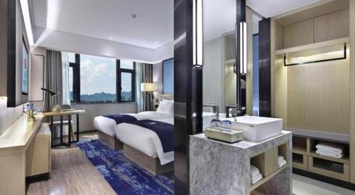 a bathroom with a bed and a sink at Echarm Hotel Guilin North High Speed Railway Station in Guilin