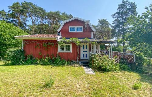 a red house with a white door in a yard at 2 Bedroom Stunning Home In Kalmar in Kalmar
