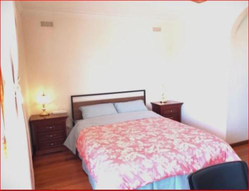 a bedroom with a large bed with two night stands at Charming Three-Bedroom Holiday Home Near Tourist Attractions in Werribee