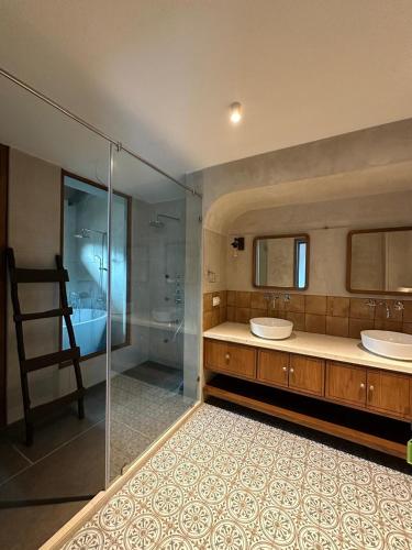 a bathroom with two sinks and a glass shower at Trabalho de Amor in Benaulim