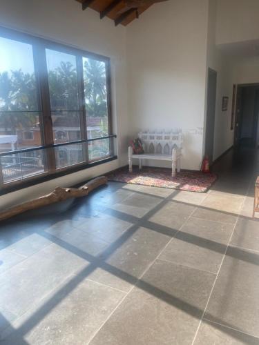 a living room with a couch and a large window at Trabalho de Amor in Benaulim