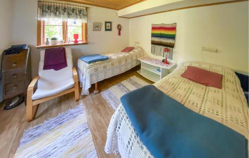 a room with two beds and a chair in it at 2 Bedroom Stunning Home In Kalmar in Kalmar