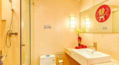 a bathroom with a sink and a shower and a toilet at Tangshan Qiangang Hotel in Qian'an