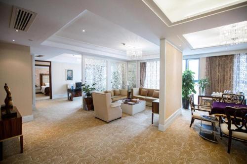 a large living room with a couch and a table at Fortune International Hotel in Xiawutun