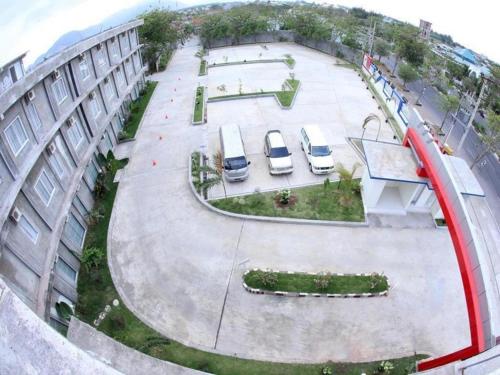 two cars parked in a parking lot next to a building at Hotel Grand Permata Hati in Banda Aceh