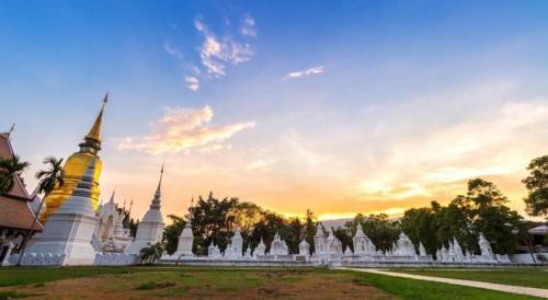 a temple with a sunset in the background at The Connect Chiang Mai in Chiang Mai
