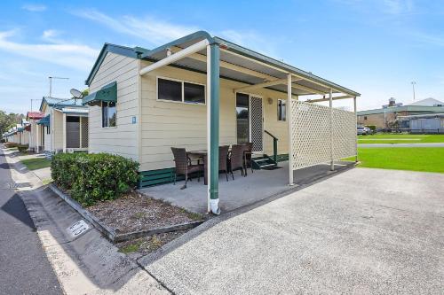 a house with a covered porch with a table at Reflections Evans Head - Holiday Park in Evans Head