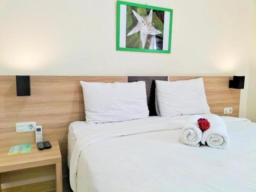 a hotel room with two beds with towels at GARDEN HOTEL MAJALENGKA in Majalengka