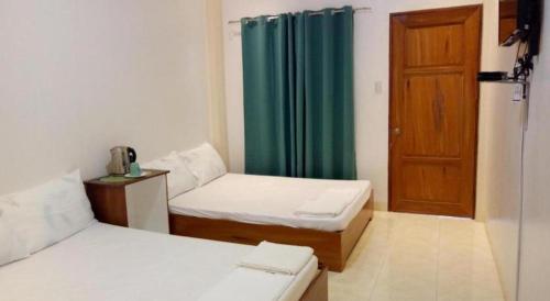 a room with two beds and a wooden door at Joaquim's Lodge in Luka