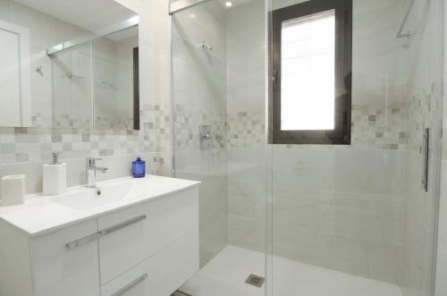 a white bathroom with a sink and a shower at Arenales Playa Superior by Mar Holidays in Arenales del Sol