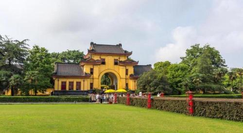 a large yellow building with a fence in front of it at JTOUR Inn Guilin Two Rivers and Four Lakes Walmart in Guilin