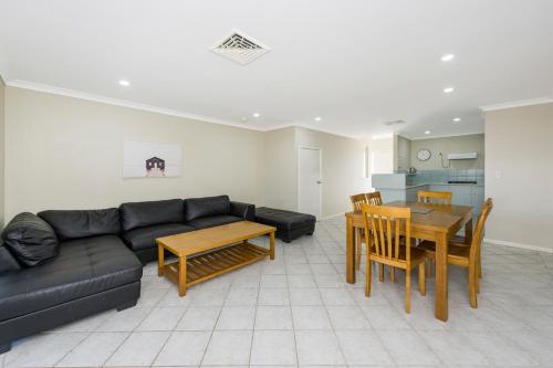 a living room with a black couch and a table at Mandurah Quay Resort in Mandurah