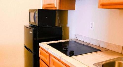 a kitchen with a black refrigerator and a microwave at Best Western Plus Guymon Hotel and Suites in Guymon