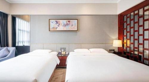 a hotel room with two beds and a window at Grand Metropark Hotel Chongqing in Chongqing