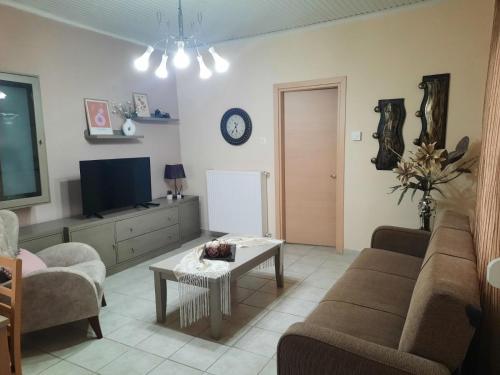 a living room with a couch and a tv and a table at Golden beach Dikella in Alexandroupoli