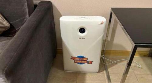 a white water heater sitting next to a table at The Bauhinia in Shenzhen