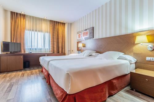 Ένα ή περισσότερα κρεβάτια σε δωμάτιο στο Sercotel Las Artes Pinto