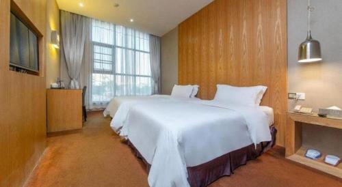 a bedroom with two beds and a large window at The Art Hotel Cai Tian Branch in Shenzhen