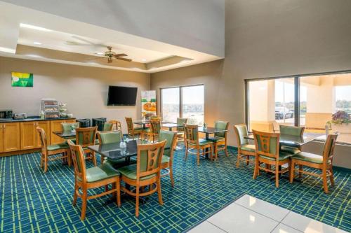 a dining room with tables and chairs and a tv at Quality Inn & Suites Jefferson City in Jefferson City