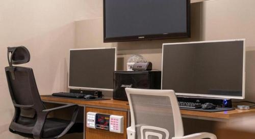 a desk with a computer and a monitor and a chair at Seven Motel Ansan in Ansan