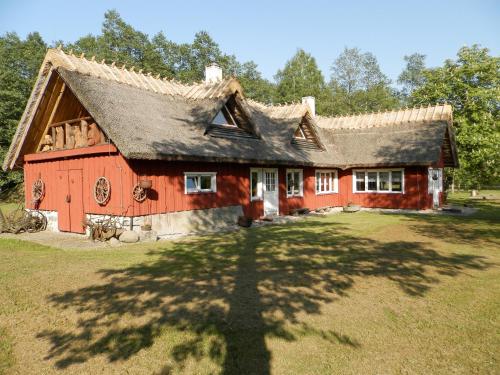 een groot rood huis met een gambrel dak bij Laugu Holiday Resort in Laugu