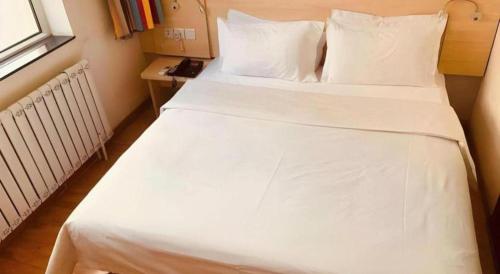 a large white bed in a room with a window at 7 Days Inn Hohhot Hailiang Xinhua Square Metro Station in Hohhot